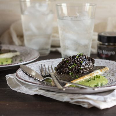 Dorada a la plancha sobre crema de guisantes con paté de aceitunas negras al ajo negro